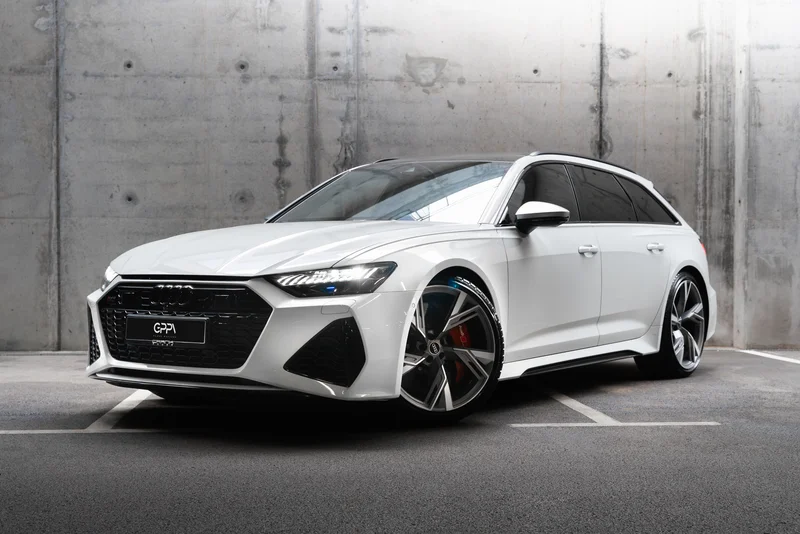 Бял Audi RS6 Performance – изглед отпред в бетонен паркинг