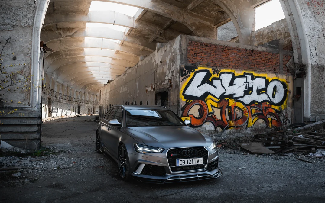 Сив Audi RS6 в изоставена хала с графити