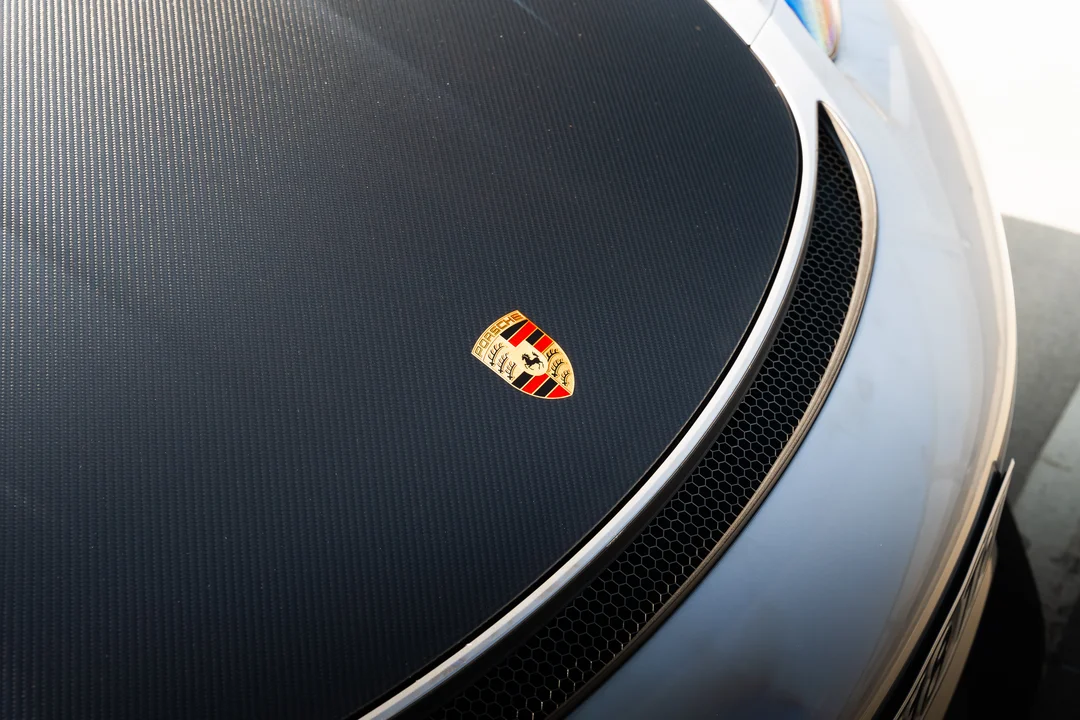 Емблема на Porsche върху карбонов капак