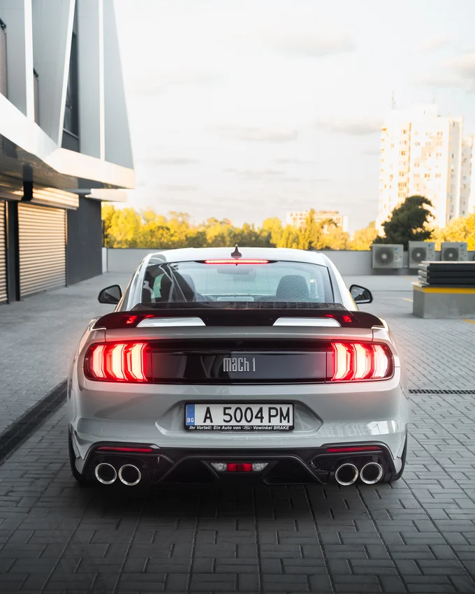 Ford Mustang отзад пред модерна сграда